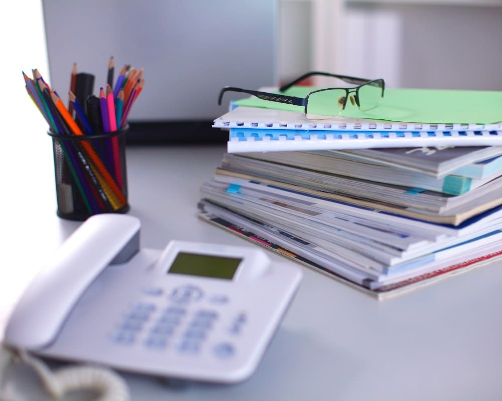 Espace de travail administratif efficace et organisé Illustration d’un bureau administratif moderne avec ordinateur portable, agenda de planification, lunettes et téléphone fixe. Un environnement professionnel dédié à la gestion efficace des services administratifs et au suivi rigoureux des dossiers.