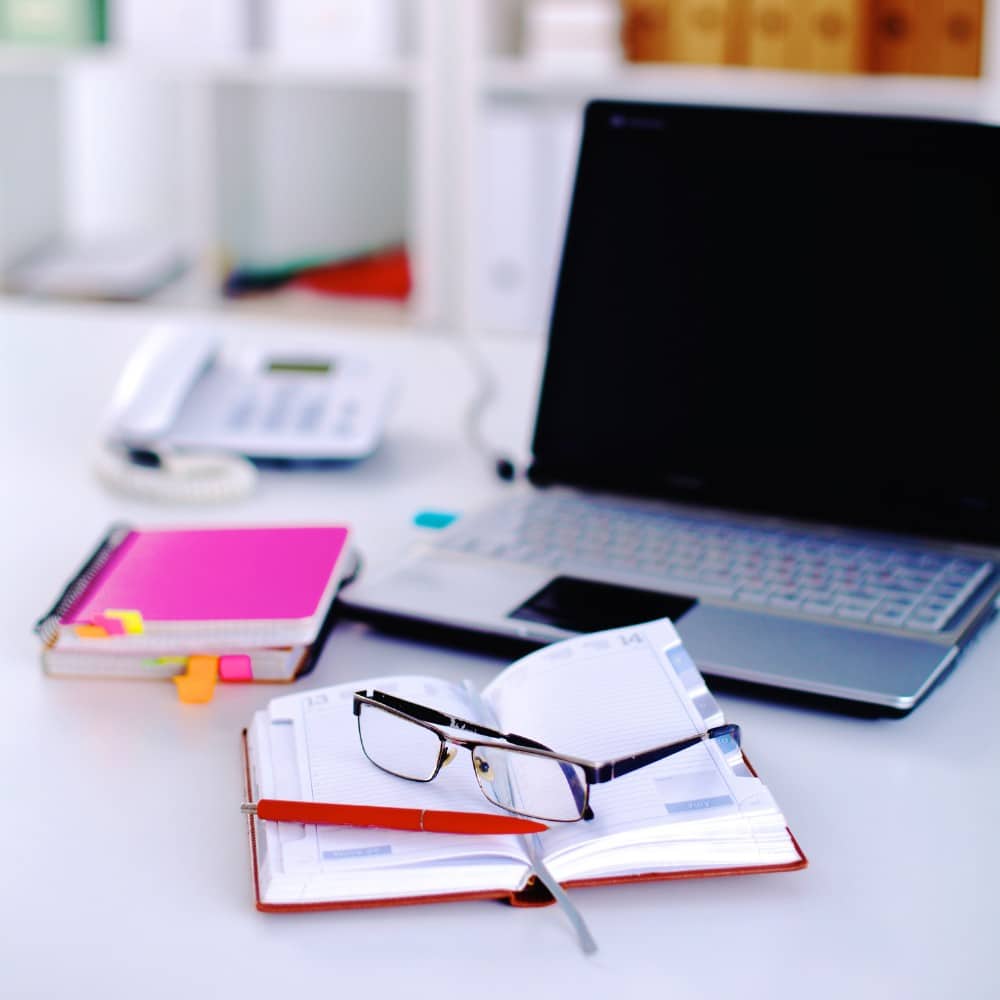 Espace de travail administratif efficace et organisé Illustration d’un bureau administratif moderne avec ordinateur portable, agenda de planification, lunettes et téléphone fixe. Un environnement professionnel dédié à la gestion efficace des services administratifs et au suivi rigoureux des dossiers.
