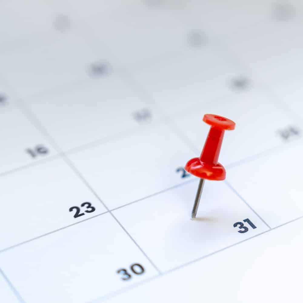 Gestion efficace des délais et échéances administratives Visuel d’un calendrier avec une punaise rouge marquant une date importante. Symbolise la rigueur dans la planification, le respect des échéances et la gestion des rendez-vous dans les services administratifs professionnels.